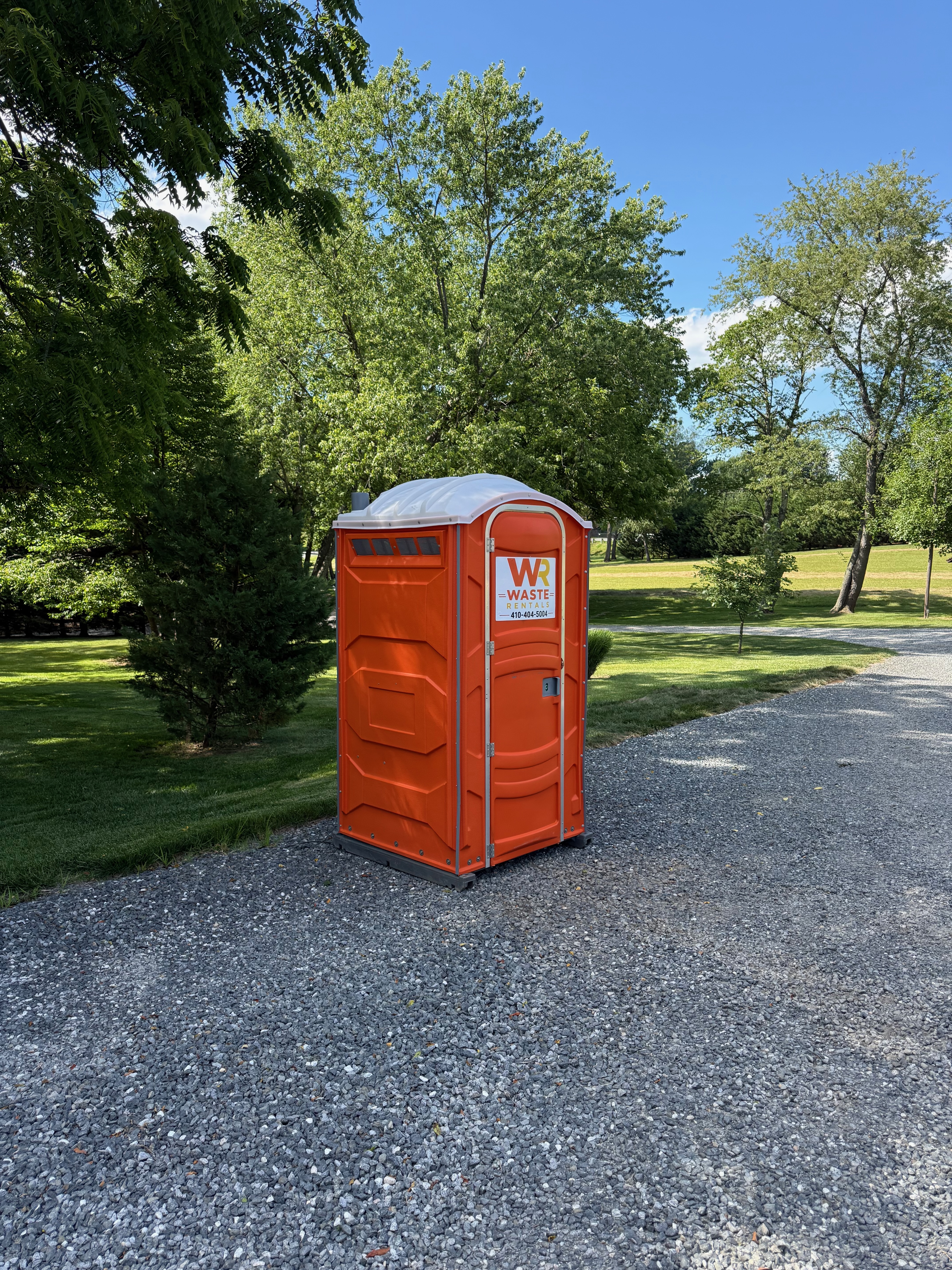 Waste Rentals portable restroom beside a gravel path in a Maryland park
